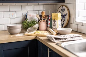 A kitchen counter with a pizza, bowls, a rolling pin, and a recipe book. - Awelfa - A lovely house accommodating 6 in Rhosneigr (Rhosneigr)