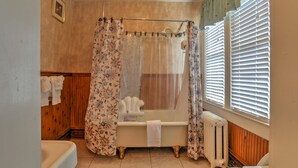 Une salle de bain avec une baignoire, des toilettes et un rideau de douche.