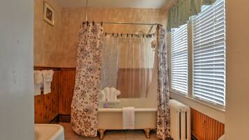 Une salle de bain avec une baignoire, des toilettes et un rideau de douche.