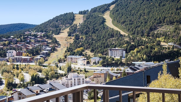 Zona residencial con casas, una pista de esquí y una montaña al fondo.