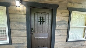 A wooden door with a decorative glass panel and a metal handle. -  ADULT ONLY Naughty Pines log cabin located in South Charleston, WV  (South Charleston)