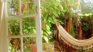 A room with a view of lush greenery and a hammock. - Villa Morena Benessere (Florianópolis)