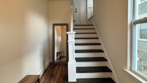 A staircase with white balusters and dark steps leading to a door. - Lovely house off Main Street (Hamilton)