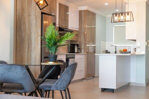 Enjoy cooking in this well-lit kitchen with sleek cabinetry, a central island, and a stainless steel range hood.