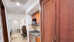 Un pasillo que da a una cocina con comedor, un armario de madera y un respiradero en el techo.