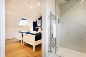 A bedroom with a bed, a bedside table, a nightstand, a window, and a shower area with a glass door. - Contractor,Discount,Parking,Wifi (Sheffield)
