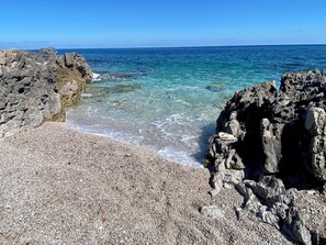 A rocky beach with clear blue water and a pebbly foreground. - Villa located 150 meters from the ocean and 5 km from the airport. Villa Melina. (Carini)