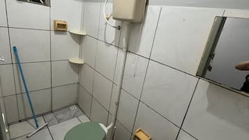 Chuveiro, toalhas de banho, sabonete, papel higiênico