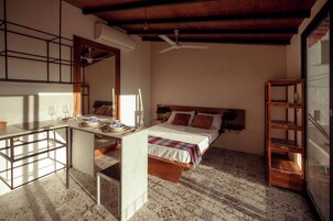Quarto com cama, mesa de cabeceira e estante de madeira.