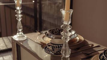 A table set with plates, cutlery, and candles in glass holders.