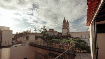 A balcony with a view of a historic church and a cityscape.