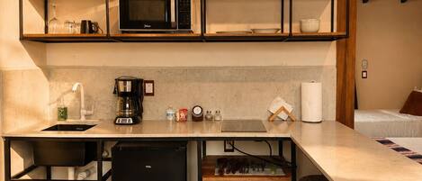 A compact kitchen with built-in appliances, a bar area, and a patterned floor.