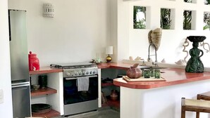 A compact kitchen with a stove, oven, and a small refrigerator.