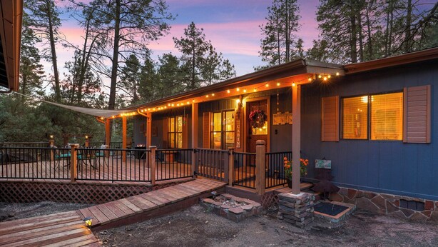 A cabin with a deck, a covered porch, and a stone foundation. - Hardscrabble Mesa | Pine Trees | Wildlife | ADA (Pine)