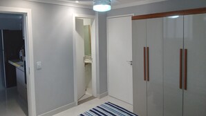 Huoneessa on kattotuuletin, vaatekaappi ja ovi, joka johtaa kylpyhuoneeseen.
