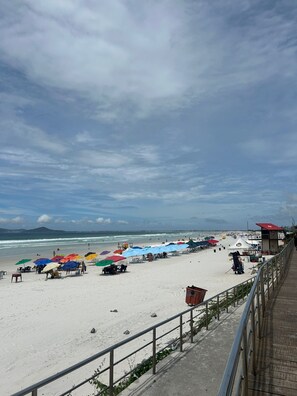 A beach with umbrellas and chairs, a lifeguard tower, and a walkway. - Spacious apartment near the main tourist attractions in Cabo Frio. Extraordinary (Centro Cabo Frio)