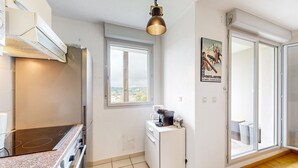 Eine moderne Küche mit Einbauherd, Kaffeemaschine und kleinem Kühlschrank.