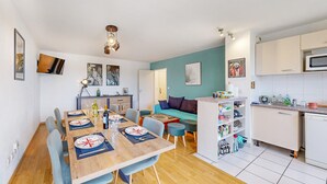 Eine moderne Wohnung mit Essbereich, Wohnzimmer und Küche.