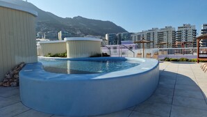 Una piscina sul tetto con vista sugli edifici circostanti e sulle montagne.