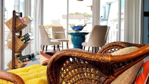 A wicker chair with a yellow cushion, a wicker basket, and a blue bowl on a table.