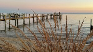 A pier extending into calm waters with a clear sky.