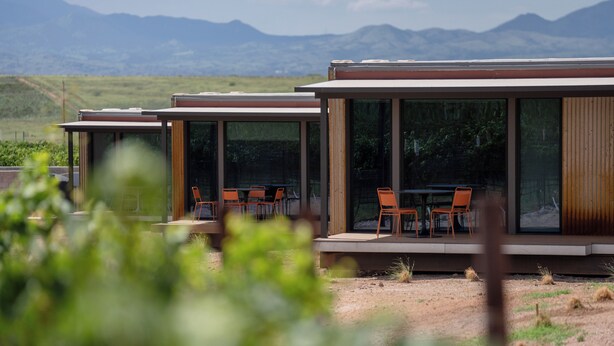 Un bâtiment moderne doté de grandes fenêtres en verre et d’espaces extérieurs aménagés pour s’asseoir.