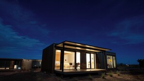 Un bâtiment moderne, de plain-pied, doté de grandes fenêtres en verre, d’un toit plat et d’une petite terrasse.