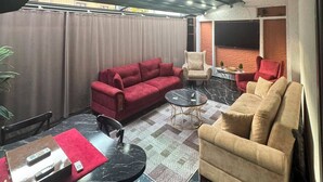 A modern living room with a red sofa, beige armchair, and a coffee table. - Viyana Suite Hotel (Istanbul)