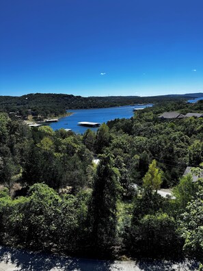 A lakeside view with dense forest, a clear sky, and a distant shoreline. - 3-BR with lake views on Indian Point close to Silver Dollar City  (Branson)