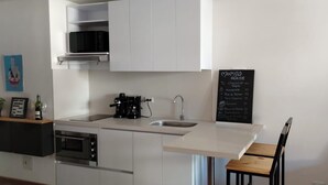 A modern kitchen with white cabinets, a coffee maker, and a chalkboard menu. - Charming 1-bedroom apartment in marvelous Bogotá with WiFi (Bogotá)