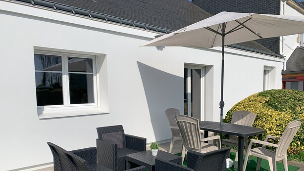 A patio with outdoor furniture, a table, and an umbrella. - Maison Ty'Bell-At the gateway to the Gulf of Morbihan  (Moustoir-Ac)