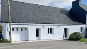 A white building with a grey roof, a garage, and a small garden. - Maison Ty'Bell-At the gateway to the Gulf of Morbihan  (Moustoir-Ac)