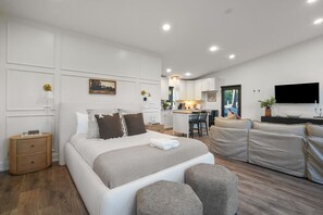 Une chambre moderne avec un grand lit, un canapé et un espace bureau.