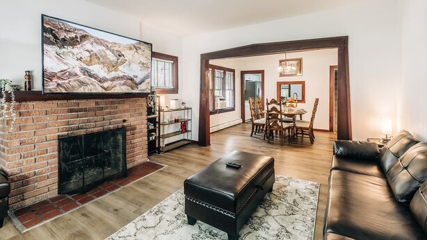A living room with a fireplace, a dining area, and a sofa.