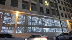 Ein mehrstöckiges Gebäude mit beleuchteten Fenstern und einer verzierten Fassade.