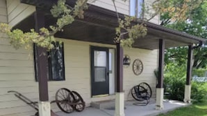 A house with a covered porch, two bicycles, and a door with a window.