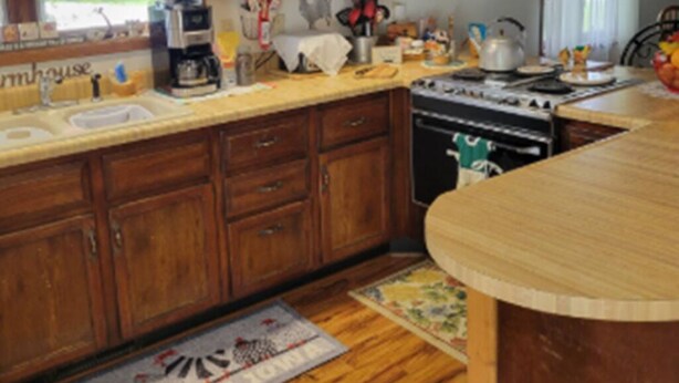 A kitchen with wooden cabinets, a stove, and various kitchen appliances.