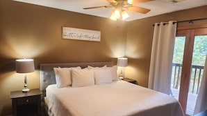 A bedroom with a large bed, two bedside lamps, a ceiling fan, and a window with curtains. - 4BR Connected Condo Near Silver Dollar City | Great for Groups | NCH 7 7-8 (Reeds Spring)