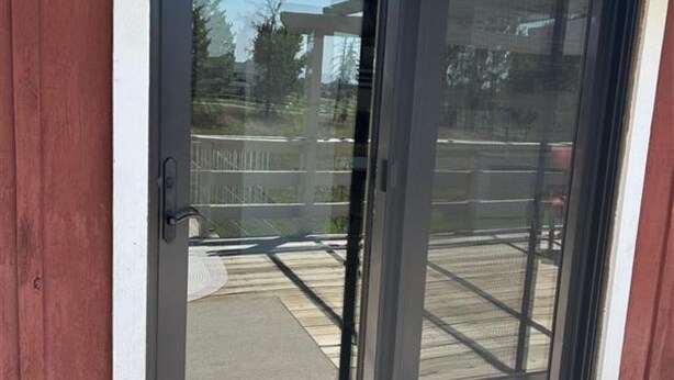 A sliding glass door with a metal handle, leading to a covered patio area.