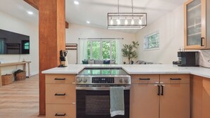 A modern kitchen with a built-in oven, wooden cabinets, and a large window.