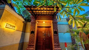 L’entrée d’une villa, avec une façade en briques, une porte en bois et une enseigne indiquant « Villa Anglia ».