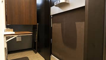 A compact kitchenette with a refrigerator, a microwave, and a small countertop.