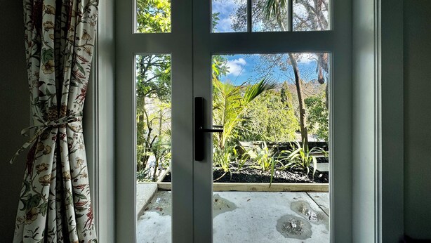A door with a view of a garden and a clear sky. - A private studio on Hobson Bay in historic Parnell. Central Auckland. (Auckland)