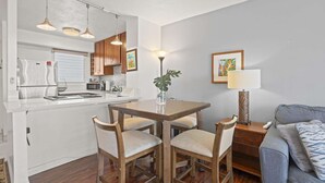 Un espace de vie compact comprenant une kitchenette, un coin repas et un coin salon.
