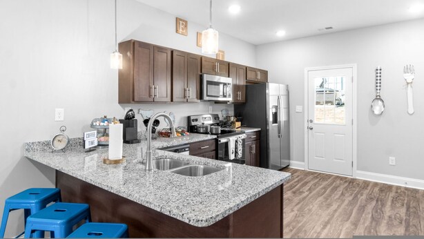 A modern kitchen with granite countertops, stainless steel appliances, and wooden cabinets.