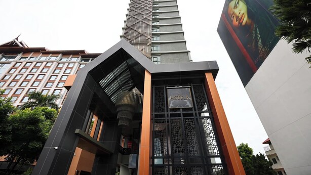 A modern building with a prominent vertical structure and a sign reading "ASTRA". - Specious Luxury 2 bedrooms Apt. (Chiang Mai)