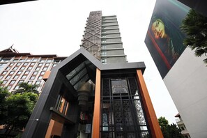 A modern building with a prominent vertical structure and a sign reading "ASTRA". - Specious Luxury 2 bedrooms Apt. (Chiang Mai)