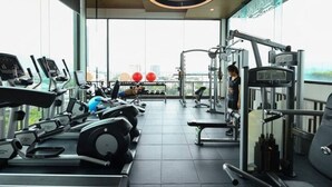 A gym with cardio machines, weightlifting equipment, and a view of the city through large windows. - Specious Luxury 2 bedrooms Apt. (Chiang Mai)