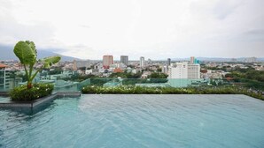 A rooftop pool with a cityscape view, including buildings and a mountain in the distance. - Specious Luxury 2 bedrooms Apt. (Chiang Mai)