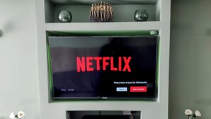 Un mueble de entretenimiento moderno con una pantalla grande que muestra 'NETFLIX' y una chimenea debajo.